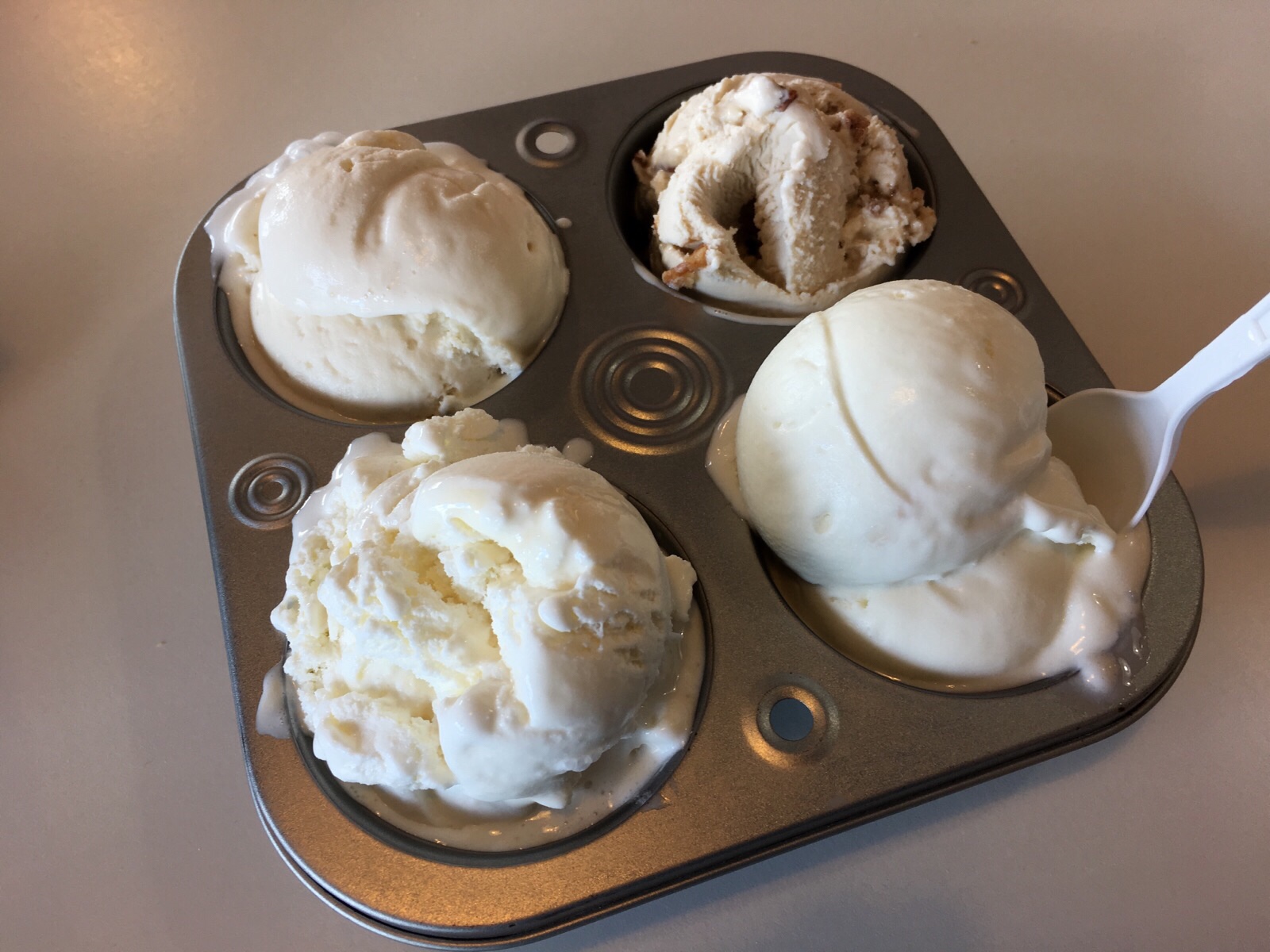 Four cupcake holder filled with ice cream scoops